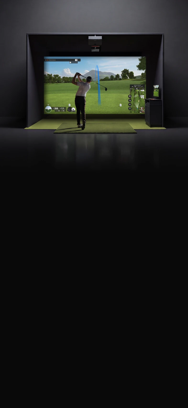 Golfer swings in an indoor simulator, displaying a virtual golf course on a large screen with lush greenery and a blue sky.